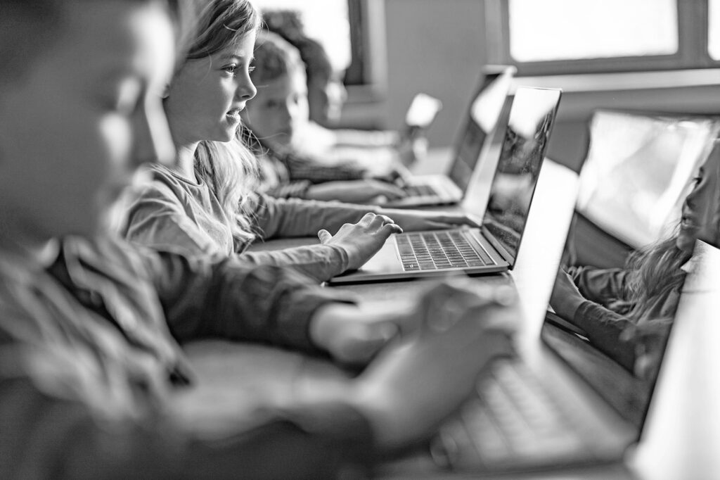 small children in class with a laptop in front of each